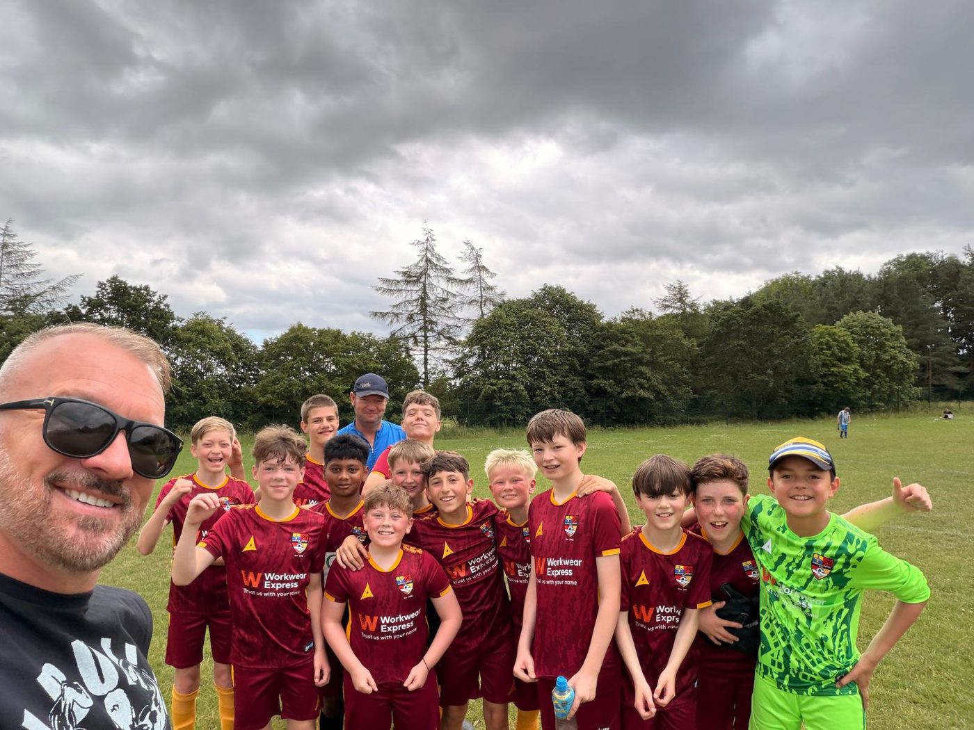 A junior football team in Workwear Express sponsored kit on the pitch after a match