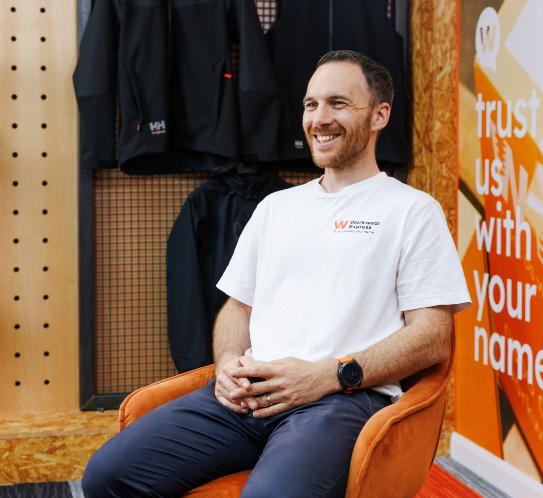 A Workwear Express team member in the Durham showroom, with kit samples on the wall behind